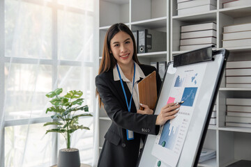 Sticker - Female office worker working on her presentation standing near white board the profit report finance