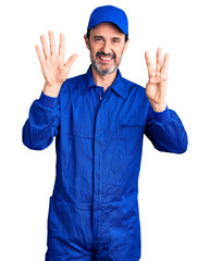 Canvas Print - Middle age handsome man wearing mechanic uniform showing and pointing up with fingers number eight while smiling confident and happy.