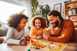 © VisualProduction - Diverse family playing board game. Family spending time together playing board game. Generative AI