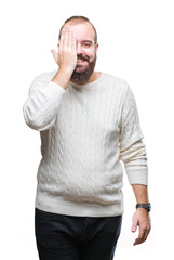 Sticker - Young caucasian hipster man wearing winter sweater over isolated background covering one eye with hand with confident smile on face and surprise emotion.