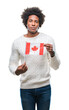 © Krakenimages.com - Afro american man flag of Canada over isolated background with a confident expression on smart face thinking serious