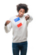 © Krakenimages.com - Afro american man flag of France over isolated background pointing with finger to the camera and to you, hand sign, positive and confident gesture from the front