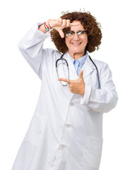 Sticker - Middle ager senior doctor woman over isolated background smiling making frame with hands and fingers with happy face. Creativity and photography concept.