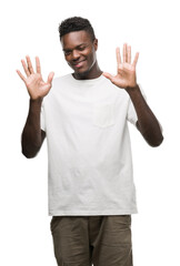 Canvas Print - Young african american man wearing white t-shirt showing and pointing up with fingers number ten while smiling confident and happy.