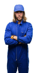 Poster - Young handsome mechanic man with long hair over isolated background skeptic and nervous, disapproving expression on face with crossed arms. Negative person.