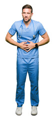 Poster - Handsome doctor man wearing medical uniform over isolated background with hand on stomach because indigestion, painful illness feeling unwell. Ache concept.