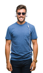 Poster - Young handsome man wearing headphones listening to music over isolated background with a happy and cool smile on face. Lucky person.