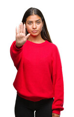 Wall Mural - Young beautiful arab woman wearing winter sweater over isolated background doing stop sing with palm of the hand. Warning expression with negative and serious gesture on the face.