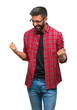 © Krakenimages.com - Adult hispanic man wearing glasses over isolated background very happy and excited doing winner gesture with arms raised, smiling and screaming for success. Celebration concept.
