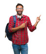© Krakenimages.com - Adult hispanic student man wearing headphones and backpack over isolated background smiling and looking at the camera pointing with two hands and fingers to the side.
