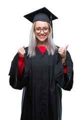 Sticker - Young blonde woman wearing graduate uniform over isolated background excited for success with arms raised celebrating victory smiling. Winner concept.