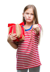 Wall Mural - Young beautiful girl giving christmas or valentine gift over isolated background pointing with finger to the camera and to you, hand sign, positive and confident gesture from the front