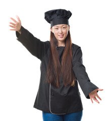 Sticker - Young Chinese woman over isolated background wearing chef uniform looking at the camera smiling with open arms for hug. Cheerful expression embracing happiness.