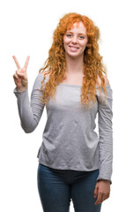 Wall Mural - Young redhead woman showing and pointing up with fingers number two while smiling confident and happy.