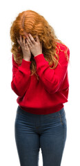 Wall Mural - Young redhead woman wearing red sweater with sad expression covering face with hands while crying. Depression concept.