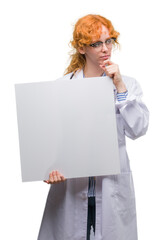 Poster - Young redhead doctor woman holding banner serious face thinking about question, very confused idea