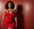 Portrait beautiful confidence african american woman plus size model posing in red dress on red background. Generative AI
