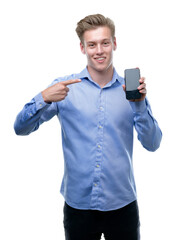 Wall Mural - Young handsome blond man using smartphone very happy pointing with hand and finger