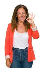 Poster - Beautiful middle age business adult woman over isolated background smiling positive doing ok sign with hand and fingers. Successful expression.