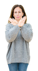 Canvas Print - Beautiful middle age woman wearing winter sweater over isolated background Rejection expression crossing arms and palms doing negative sign, angry face