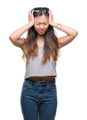 Wall Mural - Young asian woman wearing sunglasses over isolated background suffering from headache desperate and stressed because pain and migraine. Hands on head.