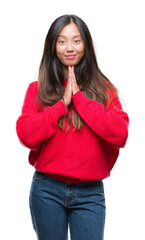 Sticker - Young asian woman wearing winter sweater over isolated background praying with hands together asking for forgiveness smiling confident.