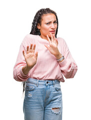 Wall Mural - Young braided hair african american girl wearing sweater over isolated background disgusted expression, displeased and fearful doing disgust face because aversion reaction. With hands raised