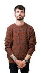 Sticker - Young handsome man wearing winter sweater over isolated background Relaxed with serious expression on face. Simple and natural looking at the camera.