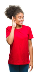 Poster - Young afro american woman over isolated background smiling with hand over ear listening an hearing to rumor or gossip. Deafness concept.