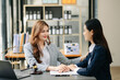 © Nuttapong punna - Business people compassionately holding hands and discussing contract papers with laptop and tabletat office
