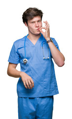 Wall Mural - Young doctor wearing medical uniform over isolated background mouth and lips shut as zip with fingers. Secret and silent, taboo talking
