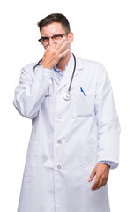 Sticker - Handsome young doctor man smelling something stinky and disgusting, intolerable smell, holding breath with fingers on nose. Bad smells concept.