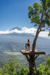 © Julija - Mother and daughter tourists enjoying travel around Bali island , Indonesia. They stands on photo location on the tree with view on Agung Mountain