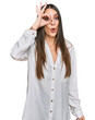 © Krakenimages.com - Young beautiful woman wearing casual white shirt doing ok gesture shocked with surprised face, eye looking through fingers. unbelieving expression.