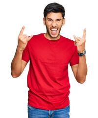 Wall Mural - Young handsome man wearing casual red tshirt shouting with crazy expression doing rock symbol with hands up. music star. heavy music concept.