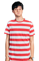 Poster - Handsome hipster young man wearing casual striped t shirt puffing cheeks with funny face. mouth inflated with air, crazy expression.