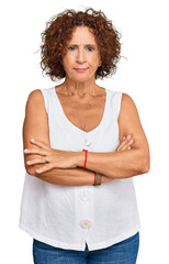 Wall Mural - Beautiful middle age mature woman wearing casual white shirt skeptic and nervous, disapproving expression on face with crossed arms. negative person.