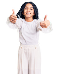 Wall Mural - Cute african american girl wearing casual white tshirt approving doing positive gesture with hand, thumbs up smiling and happy for success. winner gesture.