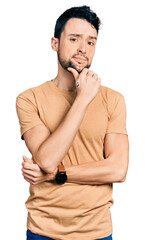 Poster - Hispanic man with beard wearing casual t shirt with hand on chin thinking about question, pensive expression. smiling with thoughtful face. doubt concept.