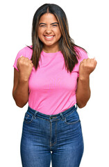 Poster - Young latin girl wearing casual clothes excited for success with arms raised and eyes closed celebrating victory smiling. winner concept.