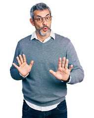 Poster - Middle age hispanic with grey hair wearing glasses moving away hands palms showing refusal and denial with afraid and disgusting expression. stop and forbidden.