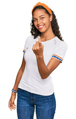 Sticker - Young african american girl wearing casual clothes beckoning come here gesture with hand inviting welcoming happy and smiling