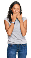 Wall Mural - Young african american girl wearing casual clothes laughing and embarrassed giggle covering mouth with hands, gossip and scandal concept