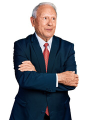 Canvas Print - Senior business man with grey hair with arms crossed gesture smiling looking to the side and staring away thinking.