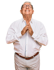 Wall Mural - Senior caucasian man wearing business shirt and glasses begging and praying with hands together with hope expression on face very emotional and worried. begging.