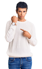 Sticker - Young african amercian man wearing casual clothes in hurry pointing to watch time, impatience, looking at the camera with relaxed expression