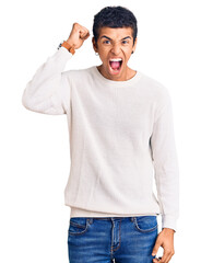 Sticker - Young african amercian man wearing casual clothes angry and mad raising fist frustrated and furious while shouting with anger. rage and aggressive concept.