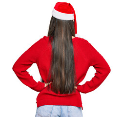 Poster - Young chinese woman wearing christmas hat standing backwards looking away with arms on body