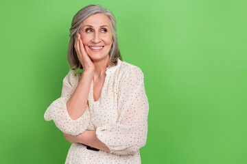 Wall Mural - Photo of good mood thoughtful lady wear beige dress arm cheek looking empty space isolated green color background