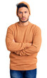 © Krakenimages.com - Handsome latin american young man wearing winter sweater and wool hat skeptic and nervous, disapproving expression on face with crossed arms. negative person.